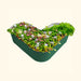 Green heart-shaped corrugated metal raised garden bed with vibrant vegetables, herbs, and colorful flowers.