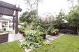 Beautiful backyard garden with corten steel raised beds, thriving vegetables, arched trellises, stone path, and a pergola.