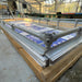 Greenhouse rolling bench with wood frame, metal rails, and blue protective sheeting, ready for plant cultivation.