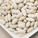 Close-up of dry white beans, possibly navy or cannellini, on a white dish. Versatile healthy legumes.