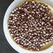 Dried cranberry beans, red and white mottled, in a light wooden bowl. Healthy legumes for cooking.