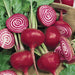 Fresh Chioggia beets with green leaves, whole and sliced revealing candy stripe pattern.