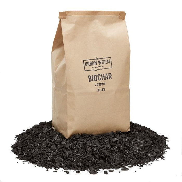 Urban Worm Biochar 2 quart (.95 lbs) bag on a pile of biochar. Organic soil amendment for gardening.
