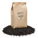 Urban Worm Biochar 2 quart (.95 lbs) bag on a pile of biochar. Organic soil amendment for gardening.