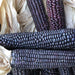 Fresh purple and blue corn cobs with light husks and silks. Heirloom corn harvest close-up.