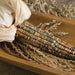 Vibrant Indian corn, partially husked, in a wooden tray with dried wheat. Autumn harvest decoration.