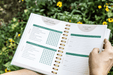 Open "Weekly Garden Habit Tracker" and "Goals" planner in a garden. Features tasks like watering, weeding, and plant care.