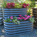 Tiered dark gray corrugated steel raised garden bed with vibrant coleus, cyclamen, pansies, and ornamental grass.