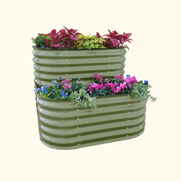 Olive green corrugated steel L-shaped two-tier raised garden bed with vibrant flowers and plants.