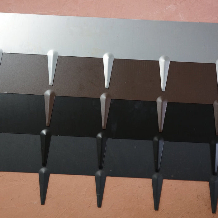 Modern metal roofing panels in silver, brown, and black with textured finish and interlocking design.