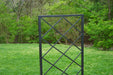 Modern black metal garden trellis featuring a diamond grid design, perfect for climbing plants in a lush yard.