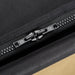 Black YKK zipper with dual pulls on textured black fabric, revealing a tan section. Durable textile and gear detail.