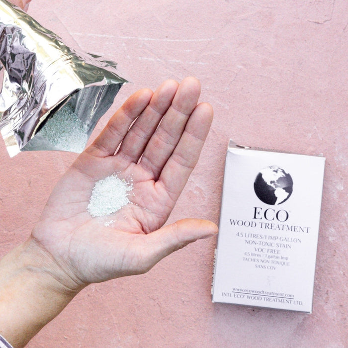 ECO WOOD TREATMENT non-toxic granular stain poured from a pouch into a hand. VOC-free wood stain for 4.5 liters.