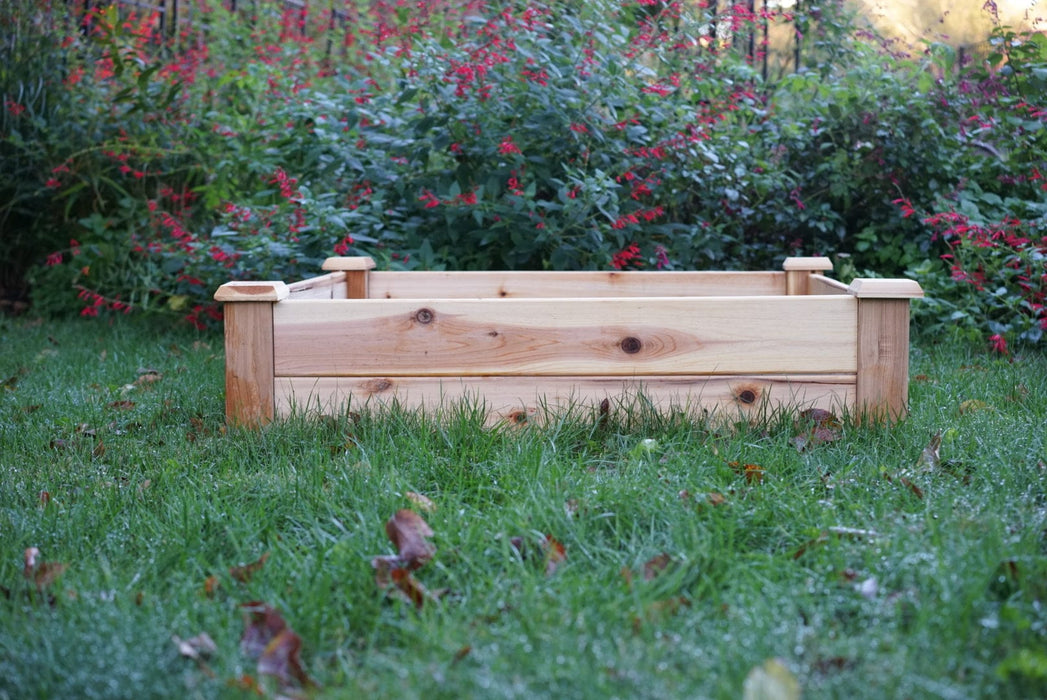 Natural wood raised garden bed on green grass, ready for planting vegetables or flowers. Backyard gardening solution.