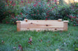 Natural wood raised garden bed on green grass, ready for planting vegetables or flowers. Backyard gardening solution.