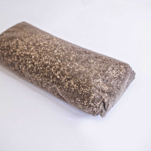 Dark granular mushroom substrate block with perlite for cultivation.