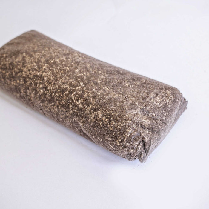 Dark granular mushroom substrate block with perlite for cultivation.