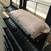 Black plastic industrial channels with a brown absorbent filter sock for environmental spill control and fluid management.