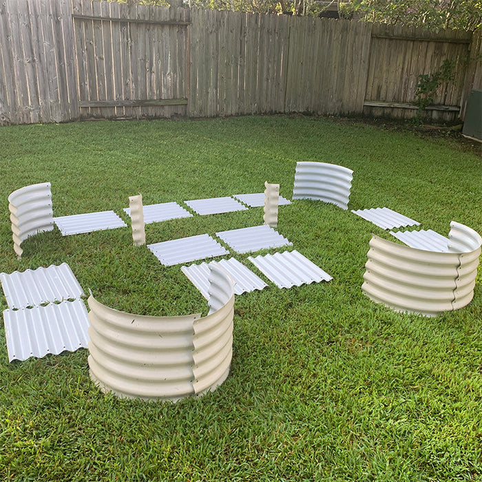 DIY raised garden bed kit: corrugated metal panels in white & beige laid on grass, ready for assembly.