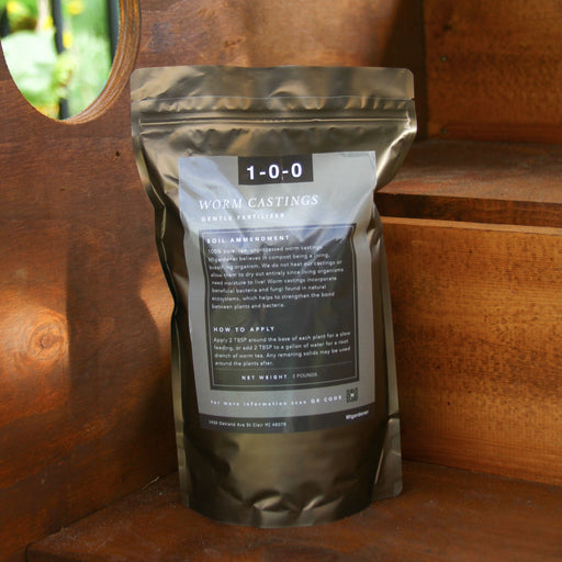 Dark pouch of 1-0-0 Worm Castings organic gentle fertilizer, 2 lbs, on wood. Natural soil amendment for plants.