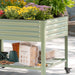 Mobile green metal raised garden bed with colorful flowers. Lower shelf stores Vego Garden coco mulch, watering can, and gloves.