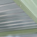 Corrugated light gray metal paneling, secured by a screw to a sage green trim. Roof or wall material.