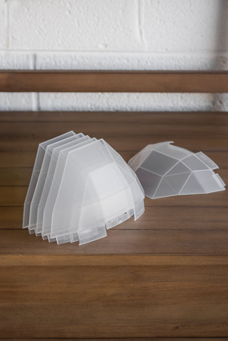 Stacked GreenStalk garden translucent plastic plant covers on wood. Dome-shaped seed starters for vertical gardens.