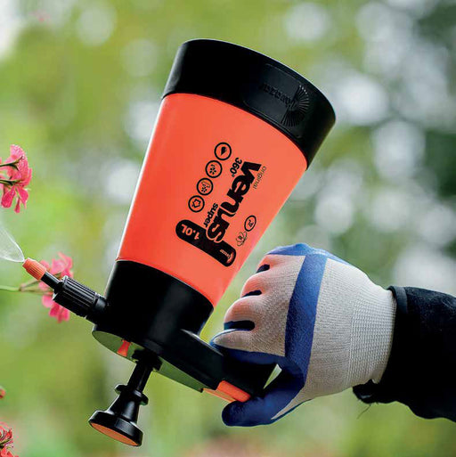 Orange Venus Super 360 garden sprayer misting pink flowers. Gloved hand operates 1.0L plant watering tool.