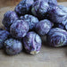 Fresh purple Brussels sprouts on a rustic wooden board. Healthy, vibrant vegetables, perfect for gourmet recipes.