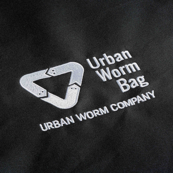 Urban Worm Bag logo and 'Urban Worm Company' white embroidery on black fabric for vermicomposting.