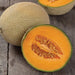 Fresh ripe cantaloupe, one whole and one halved showing vibrant orange flesh and seeds on rustic wood.