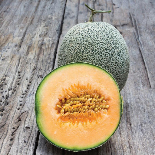 Whole and sliced cantaloupe melon with vibrant orange flesh and seeds on a rustic wooden surface. Fresh, ripe fruit.