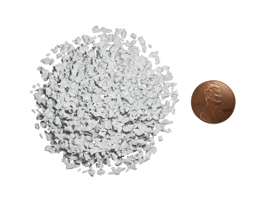 White granular material pile with a US penny for scale, showing small particle size.
