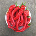 Vibrant red hot peppers in a white bowl. Freshly harvested chili peppers on stone background.