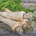 Fresh organic parsnips, white root vegetables, with green leaves on rustic wood.