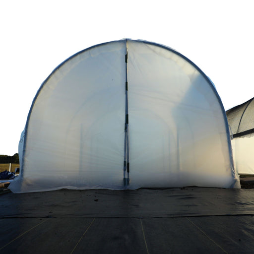 Front of clear plastic hoop house greenhouse with black ground cover. Ideal for farming & plant cultivation.