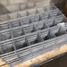 Stacked galvanized welded wire mesh panels on a wooden pallet. Durable steel for construction, fencing, reinforcement.
