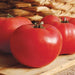 Three ripe red tomatoes on a rustic wooden board. Fresh garden produce, healthy vegetables.