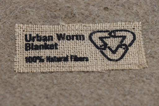 Urban Worm Blanket tag: 100% Natural Fibers and a compost symbol. Perfect for eco-friendly worm farming and gardening.