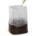 Watering potting mix in a clear plastic grow bag, ideal for seed starting and plant propagation.