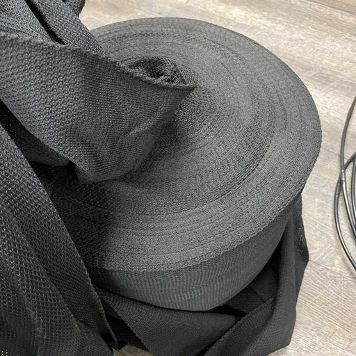 Black mesh fabric roll, durable woven textile for industrial use.