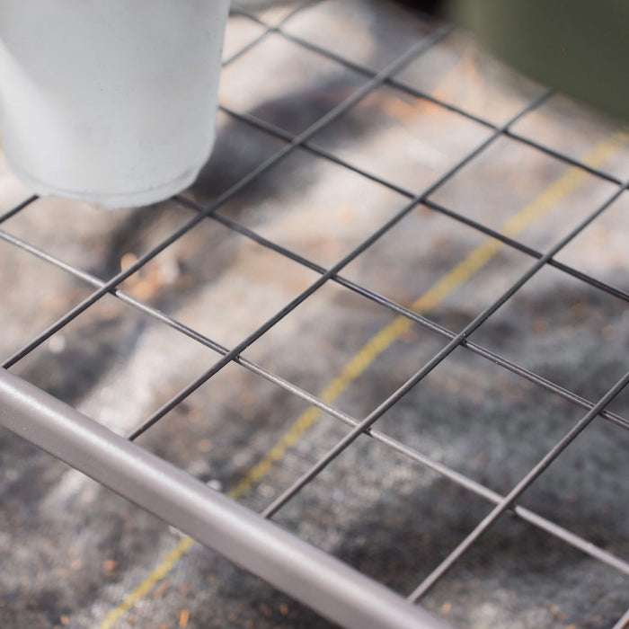 Dark grey metal wire grid shelf with a white pot, perfect for plants, greenhouse, or general storage.