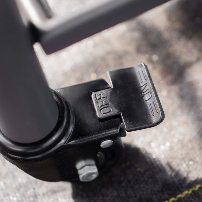 Black caster wheel brake lever showing "OFF" position. Durable locking mechanism for heavy-duty furniture or equipment mobility.