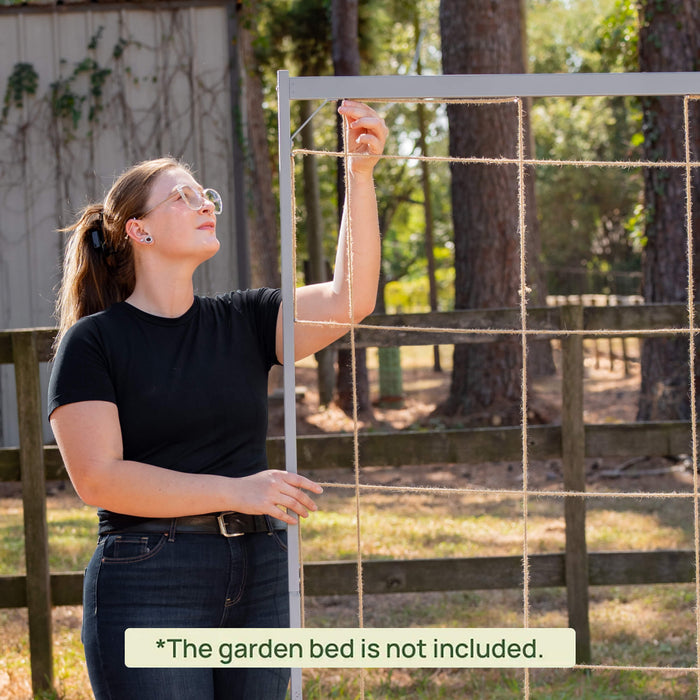 Woman assembling a garden trellis with jute twine for vertical plant support outdoors.