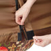 Hand zipping brown outdoor gear with Velcro closures, revealing mushroom print fabric.