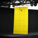 Yellow sticky insect trap hanging from wires, with grid pattern for pest monitoring and control.