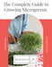 The Complete Guide to Growing Microgreens book by Gardenary. Person harvesting fresh microgreens with scissors.