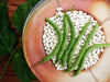 Rustic plate of dried white beans topped with fresh green beans and green leaves. Healthy legumes.