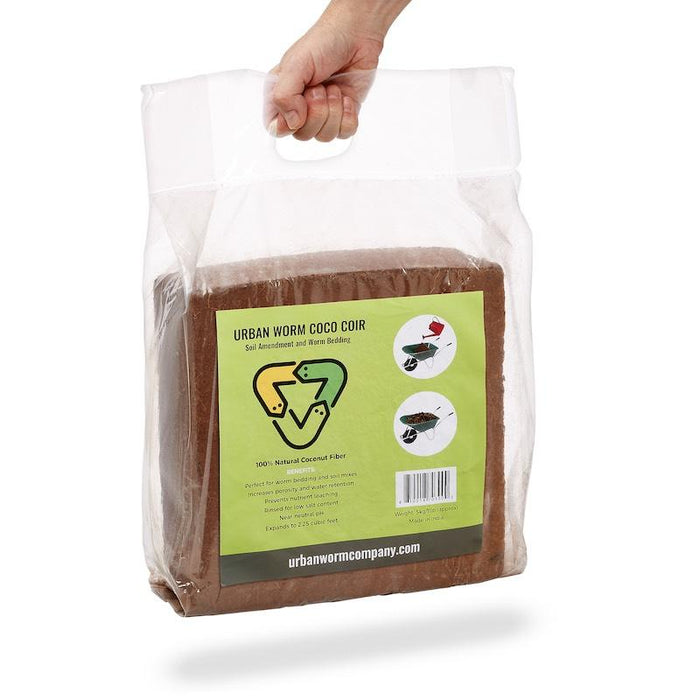 Hand holding Urban Worm Coco Coir brick, natural coconut fiber for soil amendment & worm bedding.