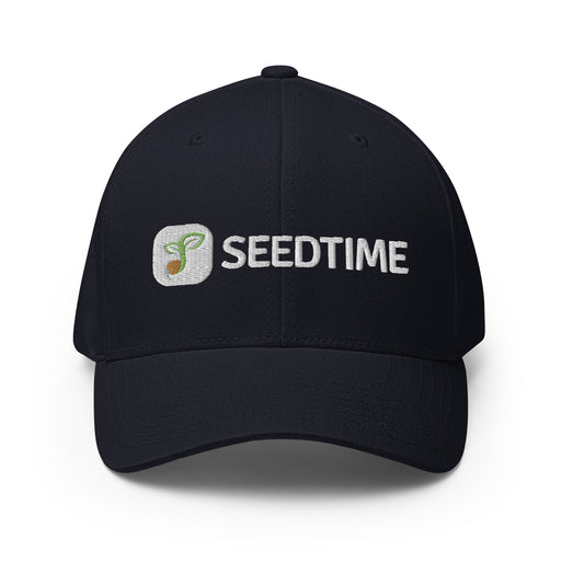 Navy blue fitted baseball cap with embroidered Seedtime logo: green sprout icon and white "SEEDTIME" text.
